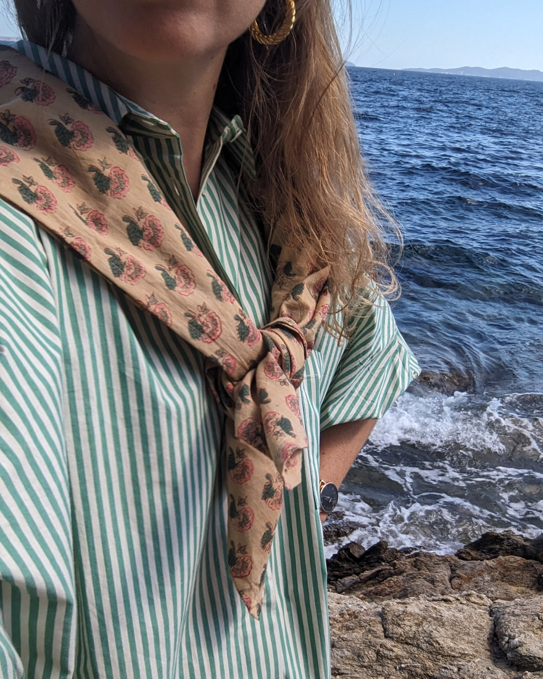 Foulard fleuri rose porté sur les épaules et noué à l'avant au bord de la mer